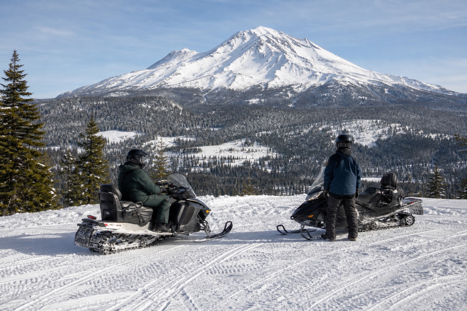 Two snowmobilers at a Mount Shasta overlook
